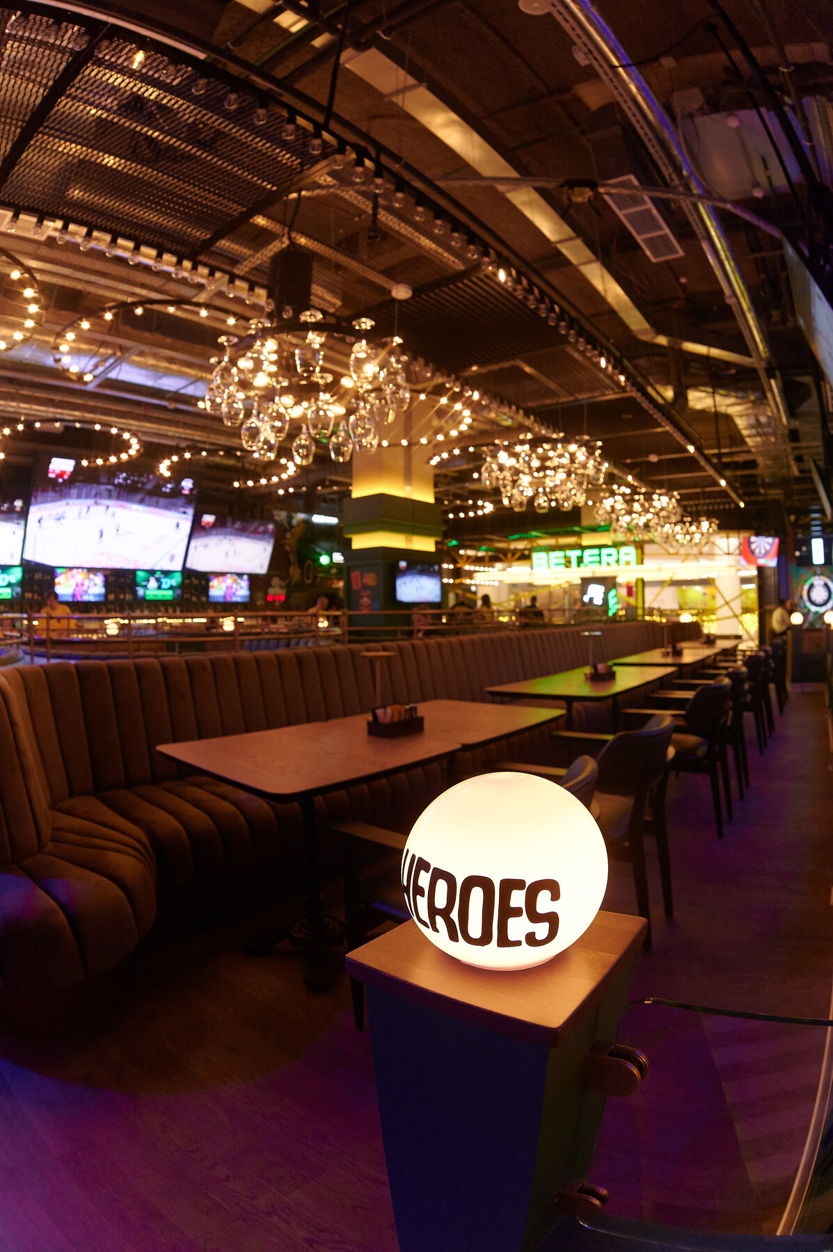 The HEROES bar with chandeliers and chesterfield banquettes.