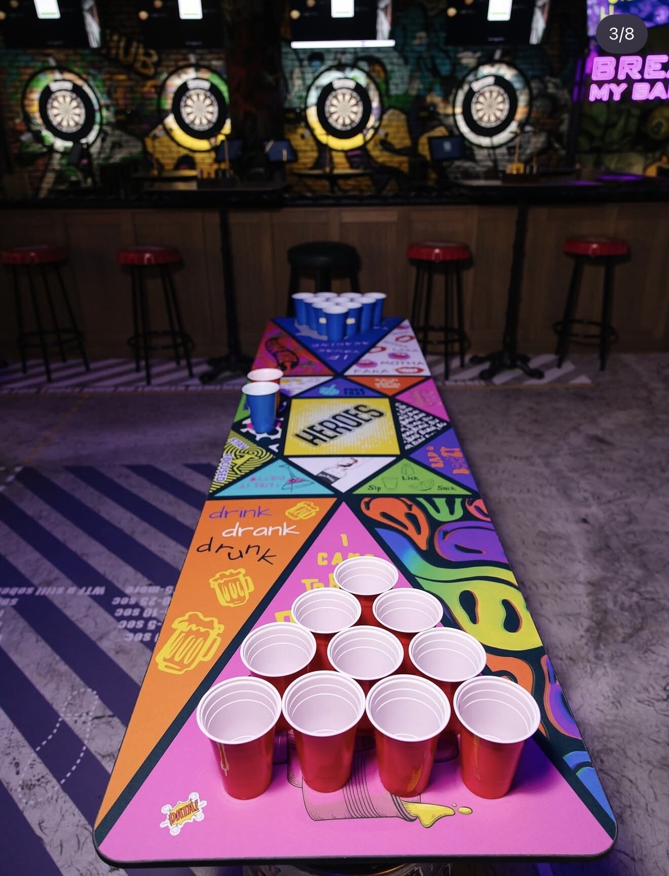 Beer pong cups on a graphic-printed game table.